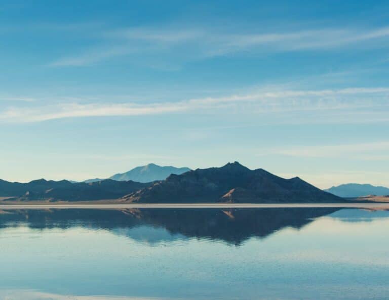 Live Strong House - We See It Differently | Mountain landscape reflected on calm water.
