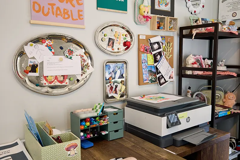 An office area with a printer and knick knacks on the wall